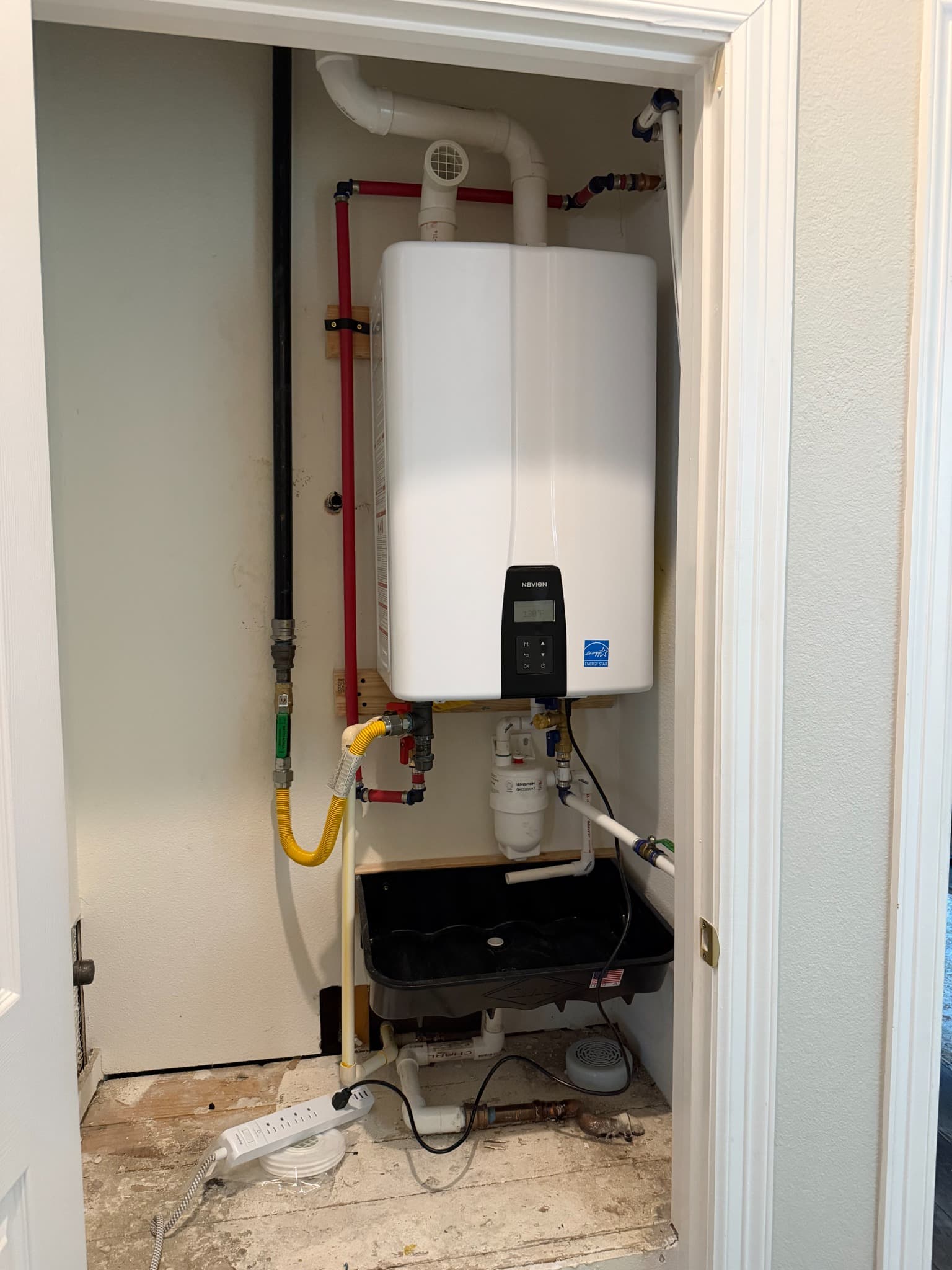 Tankless water heater installed in a utility closet
